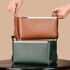 two women's hands holding purses stacked on top of each other in different colors