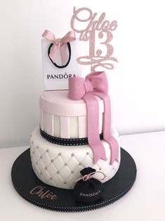 a pink and white cake with a shopping bag on top