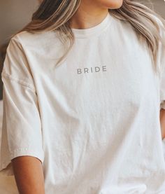 Celebrate your special day with effortless style and comfort in our Bride Oversized Shirt. Designed with the modern bride in mind, this shirt offers a relaxed, chic look that's perfect for pre-wedding prep, cozy mornings, or lounging with your bridal party. Key Details: Material: Made from high-quality, ultra-soft cotton blend for a cozy, breathable feel. Fit: Features an oversized, relaxed silhouette that drapes beautifully and allows for easy movement. Design: Classic crew neckline and drop sh Spring Wedding Crew Neck Top, Chic Short Sleeve Wedding Tops, Chic Short Sleeve Tops For Wedding, Relaxed Fit Crew Neck Top For Wedding, White Crew Neck Top For Bridesmaids, White Short Sleeve Top For Bridesmaids, White Relaxed Fit Top For Wedding, Cotton Top For Wedding In Spring, White Relaxed Fit Shirt For Brunch