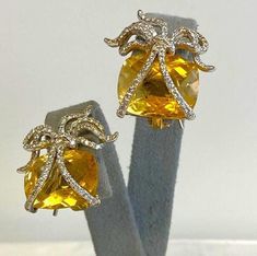 Pair 18K Yellow Gold Citrine & Diamond Earrings DescriptionPair 18K Yellow Gold Earrings; Convertible Posts; Omega Clip; 178 Round Brilliant Cut Diamonds 0.89 Carat Total Weight, I-1, H; Bow Motif; 2 Checkerboard Cushion Cut Citrine 16.84 Carat Total Weight; 14.0 Grams Payment All payments must be made through PayPal, NO EXCEPTIONS. We cannot accept payment plans. We do not offer Layaway. Shipping We ship via USPS Registered Mail, Return Receipt in order to provide tracking and insured delivery, which usually takes 5-7 days ($25) **OVERNIGHT SHIPPING available upon request ($40); please request overnight shipping upon your winning bid!! Expedited shipping fee will be added to your total AND expedited shipping service will be arranged for you.  We ship within one business day (holidays and Luxury Yellow Gold Citrine Earrings, Luxury Yellow Gemstone Earrings, Yellow Citrine Earrings For Formal Occasions, Yellow Earrings With 17 Jewels For Formal Occasions, Yellow Citrine Earrings For Wedding, Formal Yellow Earrings With 17 Jewels, Formal Yellow Citrine Earrings, Formal Yellow Clip-on Earrings, Yellow Citrine Earrings With Prong Setting