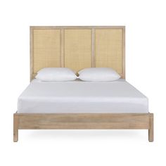 a bed with two pillows on top of it and a headboard made out of wood