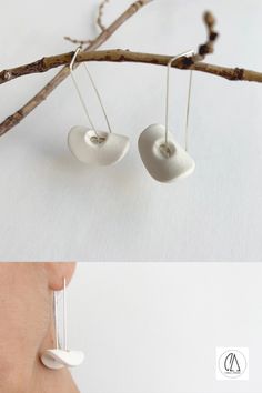 two pictures of the same pair of earrings hanging from a tree branch, and one is made out of white ceramic