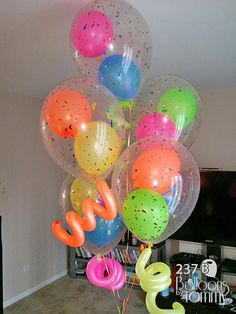 a bunch of balloons that are on top of each other in the middle of a room