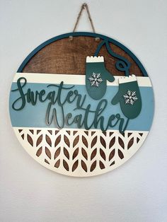 a wooden sign hanging on the side of a wall that reads, sweaterer weather