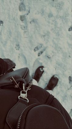 a person standing in the snow with their feet up