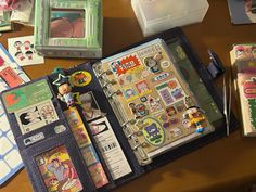 an open book with various stickers on it sitting on a table next to other items