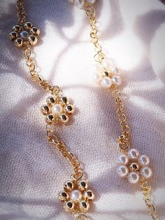 A modern, feminine piece for your collection, this Gold Daisy Bracelet is a darling addition. Made from 18kt Gold Filled, choose from two styles or layer both for the ultimate girlie stack.✦ DETAILS ✦✧ Name: Pua (puu AH) - flower.✧ 18kt Gold Filled.✧ Imitation pearls.✧ You will receive 1 bracelet.✧ All Ke Aloha Jewelry pieces come packaged thoughtfully, beautifully, and ready for gift giving.✧ Unless otherwise noted in the listing description, all pieces are sold individually. Photos with models Hypoallergenic Feminine Gold Jewelry, Feminine Hypoallergenic Gold Jewelry, Gold Bracelet With Pearl Chain For Party, Gold Pearl Chain Bracelets For Party, Gold Pearl Chain Bracelet For Party, Handmade Gold Feminine Bracelets, Handmade Feminine Gold Bracelets, Feminine Gold Bracelet Jewelry, Elegant Hypoallergenic Bracelets For Party