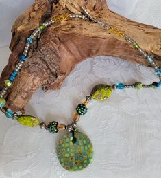 I make all of my polymer clay focal beads right here in my studio. Chartreuse, robins egg blue, gold and brown are the perfect color combo for this mod cane pendant.  Paired with unique and one of a kind beads to highlight these great colors, this necklace can be your all seasons accessory.  Just large enough to grab your attention, but not large enough to overwhelm, this piece will be the focus of any great outfit.  About 20 inches in length with a sterling silver toggle clasp.  This necklace i Large Polymer Clay Bead Jewelry, Polymer Clay Jewelry With Large Round Beads, Artisan Green Beaded Round Necklace, Green Nature-inspired Beaded Necklace With Round Beads, Round Beaded Polymer Clay Jewelry, Green Bohemian Polymer Clay Jewelry, Polymer Clay Round Beads For Jewelry Making, Bohemian Polymer Clay Round Beads Jewelry, Bohemian Beaded Polymer Clay Necklaces