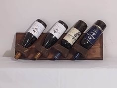 Farmhouse / Rustic wooden wall-mount wine rack for 4 bottles.  Available in right-hand (pictured dark brown) or left-hand (pictured unfinished). The back board has a 'live edge' perimeter.  The 4-bottle rack's surfaces and corners were treated to enhance the grain's texture & add to the aged look.  The bottle holes were also given an aged appearance. The stain used is semi-transparent, water-based.  Other colors are available, as is unfinished for you to paint/stain to your liking. The last image shows other available wine racks:  4-bottle racks (left-hand shown unfinished, right-hand shown dark brown); & a 7-bottle, arced rack (also dark brown).  Please visit my Etsy Shop for details.  Please contact me for color options, otherwise it will be dark brown. 22.75" wide x 7.25" high x 4.25" d Wine Rack Modern, Homemade Wine Rack, Wine Bottle Display, Wood Wine Rack, Wall Mounted Wine Rack, Wood Wine Racks, Bottle Display, Wine Bottle Holder, Wine Display