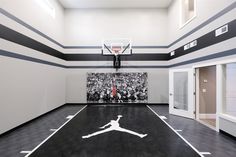 an indoor basketball court with black and white lines on the floor, painted in grey and white