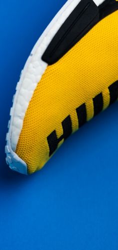 a yellow and black tennis shoe on a blue background