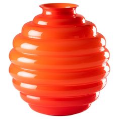 an orange vase sitting on top of a white table