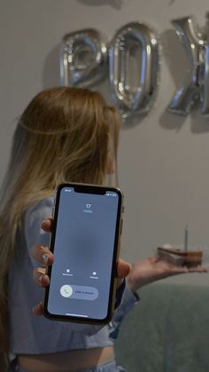 a woman is holding up her cell phone