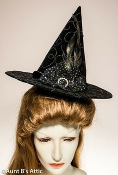 Adorable mini witch hat in rich black velvet, with a glitter swirled patterned design throughout. Black satin band, trimmed with black feathers, sequin netting, and a rhinestone ring. Elastic strap to hold in place. 8" tall, with a 2 1/2" brim. Lovely & Elegant. Novelty Brimmed Halloween Costume Hats And Headpieces, Novelty Brimmed Halloween Costume Hat, Black Top Hat For Halloween, Fitted Witchy Hat For Halloween, Black Brimmed Halloween Hat, Halloween Fitted Wide Brim Costume Hat, Black Brimmed Hat For Halloween, Halloween Wide Brim Fitted Mini Hat, Fitted Wide Brim Halloween Costume Hat