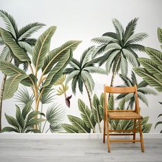 a chair sitting in front of a wall with palm trees on it