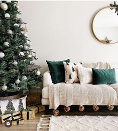 a living room with a christmas tree in the corner and other decorations on the floor