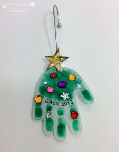 a hand shaped ornament with a star hanging from it's side on a hook