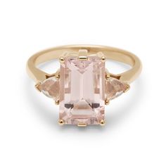 A three stone engagement ring with an emerald shape pink morganite center stone with two peach morganite trillion side stones set in yellow gold. Signature Rings, Peach Morganite, Emerald Cut Rings, Three Stone Ring, Pink Morganite, Grey Diamond, Stone Collection, Fine Jewelry Collection, Three Stone Rings