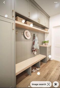 a bench in the middle of a room next to some cupboards and shelves with hats on them