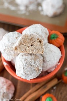 a bowl filled with powdered sugar covered cookies