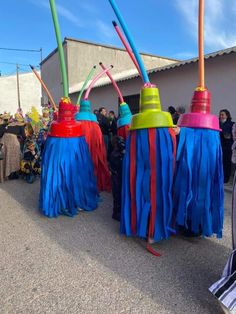 several colorful umbrellas are lined up on the street with people standing in the background