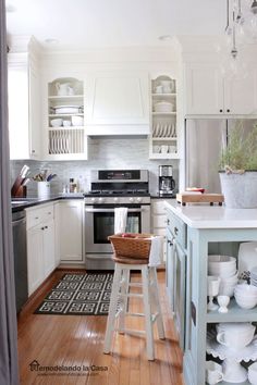 a kitchen with white cabinets and wooden floors