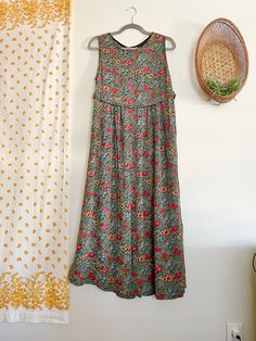 This vintage April Cornell dress is a stunning addition to any wardrobe. With a beautiful floral pattern in a range of colors, this dress is perfect for any occasion in the summer, fall, or spring. The sleeveless design and round neckline provide a comfortable and stylish fit, while the pullover closure makes it easy to wear. Made from high-quality rayon fabric, this dress is both comfortable and durable. It fully buttons down the back- which is one of my favorite features of this dress. Its long length and boho style make it a great choice for any fashion-conscious woman. This dress is a size M and is perfect for regular-sized women. Don't miss out on the chance to add this stunning vintage dress to your collection!  Measurements taken while laying flat: Pit to pit- 20" Length- 51" Waist- Bohemian Floral Print Knee-length Sundress, Vintage Boho Print V-neck Dress, Bohemian Floral Print V-neck Sundress, Hippie Floral Print V-neck Dress, April Cornell, V-neck Floral Patchwork Summer Dress, Boho Maxi, Button Down Dress, Round Neckline