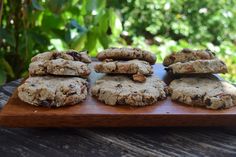 several cookies are stacked on a wooden board