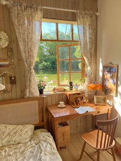 a bedroom with a bed, desk and chair in it next to a large window