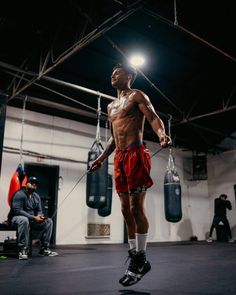 a man in red shorts standing on top of a punching bag