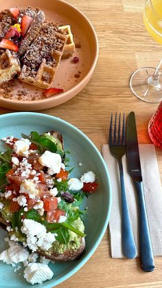 two plates of food on a table with silverware