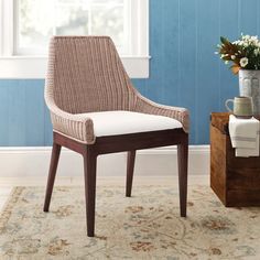 a chair sitting on top of a rug next to a wooden box with flowers in it