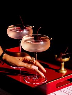 two martinis sitting on top of a red tray