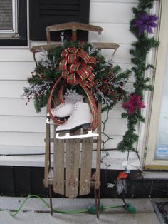 a sled with snow and ice skates on it in front of a house