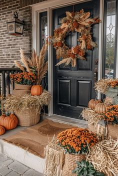 pumpkins and gourds are sitting on the front porch