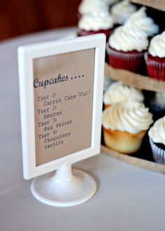 cupcakes are on display in front of a sign