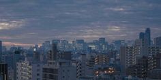 the city skyline is lit up at night, with skyscrapers in the foreground