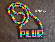 a colorful beaded necklace with the word fluf spelled in small letters on it