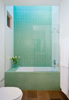 a white toilet sitting next to a bath tub in a bathroom under a skylight