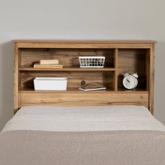 a bed with a wooden headboard and shelves above it