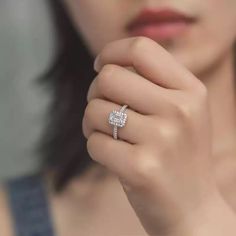 a close up of a person wearing a ring with a diamond on it's middle finger