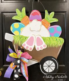 a door hanger decorated with an easter egg in a wagon and grass on it