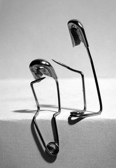 two metal objects sitting on top of a white surface next to each other in black and white