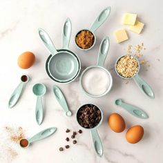 several bowls and spoons with different types of food in them on a white surface