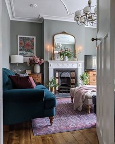 a living room filled with furniture and a fire place under a mirror on the wall