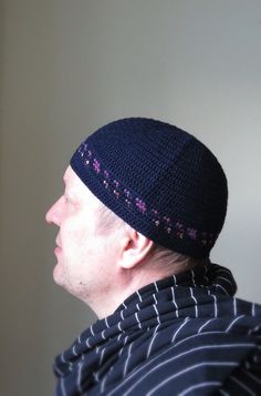 a man wearing a blue knitted hat looking off into the distance