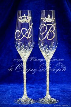 two wine glasses with the letter e and crown on each one, sitting side by side