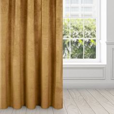 an open window with a curtain in front of it and a plant behind the curtains