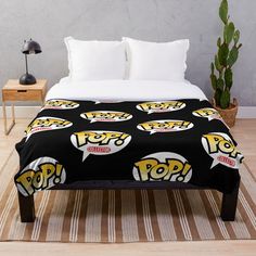 a black and yellow throw blanket with pop logo on it