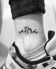 a small ankle tattoo with three deers on it